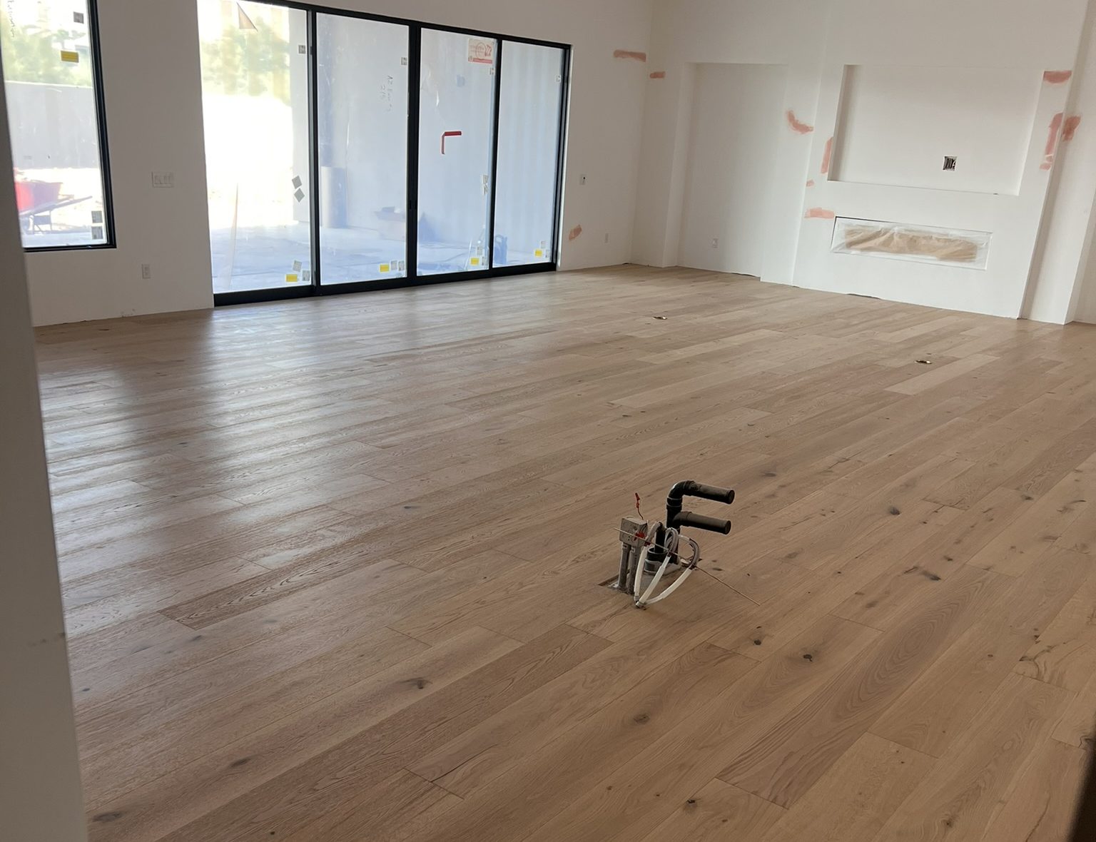 Wide plank oak floor in a great room with sliding glass doors